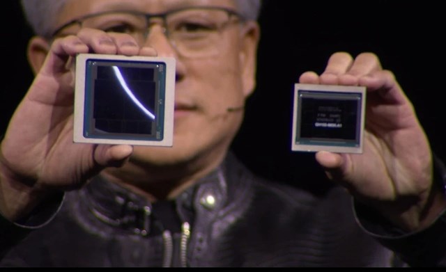 &nbsp; CEO Jensen Huang cầm hai con chip GB200 (tr&aacute;i) v&agrave; H100 (phải). Ảnh: Nvidia.