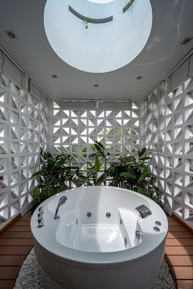 Phòng tắm thiết kế theo không gian mở sử dụng bể sục jacuzzi và gạch hoa gió vừa riêng tư vừa có thể đón ánh sáng và không khí bên ngoài. 