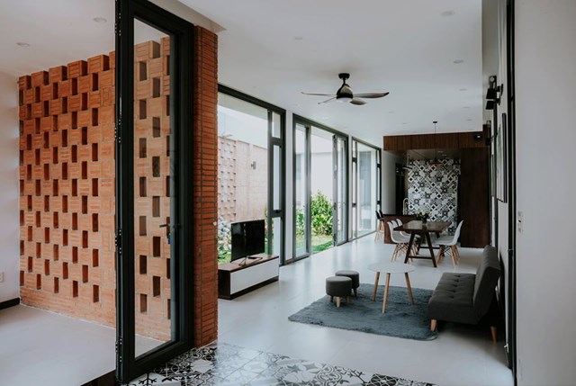 Các phòng bên trong nhà nối liền với nhau chạy dọc theo khu vườn nhỏ. Nội thất sử dụng gỗ tự nhiên nổi bật trên nền tường màu trắng. 