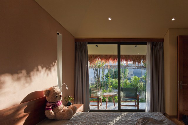Phòng ngủ của con nằm ở tầng 2 với cửa kính lớn đón nắng và hướng ra khu vườn nhỏ. 