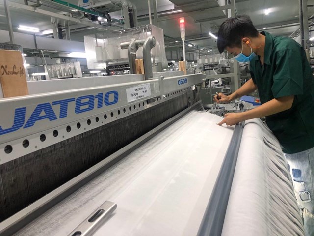 C&ocirc;ng nh&acirc;n đang kiểm tra vải dệt tại C&ocirc;ng ty dệt Bảo Minh. Nguồn: Internet