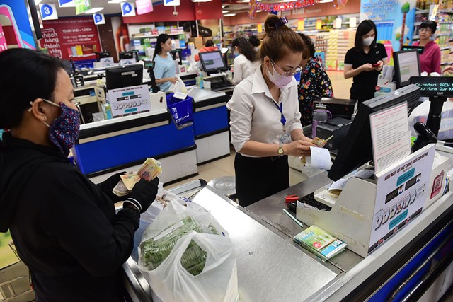 Các siêu thị in hóa đơn giấy từ máy tính tiền ra để giao cho khách hàng - Ảnh: Quang Định.