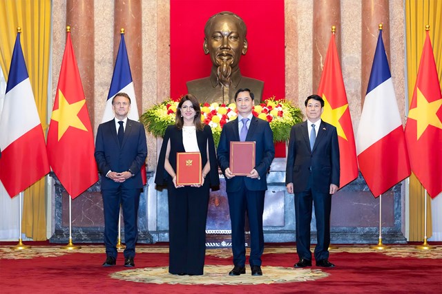&Ocirc;ng Ng&ocirc; Ch&iacute; Dũng, Tổng Gi&aacute;m đốc ki&ecirc;m Chủ tịch HĐQT C&ocirc;ng ty Vắc xin Việt Nam (VNVC) v&agrave; b&agrave; Zainab Sadat Qayyum, Chủ tịch Sanofi v&ugrave;ng Đ&ocirc;ng Nam &Aacute; - Ấn Độ trao văn kiện thỏa thuận hợp t&aacute;c chuyển giao c&ocirc;ng nghệ sản xuất vắc xin của Sanofi tại Nh&agrave; m&aacute;y Vắc xin v&agrave; Sinh phẩm VNVC trước sự chứng kiến của Chủ tịch nước Lương Cường v&agrave; Tổng thống Ph&aacute;p Emmanuel Macron. Ảnh: Hải Nam