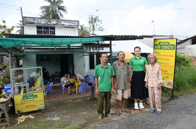 &Ocirc;ng Nguyễn Văn Tiến, B&iacute; thư chi bộ, Trưởng ấp Phước Trạch, x&atilde; Phước Thạnh v&agrave; đại diện chương tr&igrave;nh Ước mơ xanh c&ugrave;ng vợ chồng c&ocirc; Thu&yacute; trong ng&agrave;y khai trương qu&aacute;n.