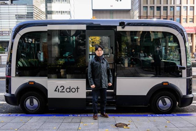 &Ocirc;ng Jeong Seong-gyun đứng cạnh chiếc xe bu&yacute;t tự l&aacute;i sản xuất bởi 42 Dot.